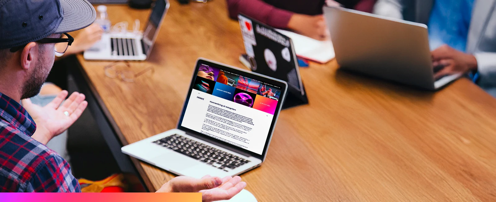 A group working around a table, one laptop showing the uptakeAI site