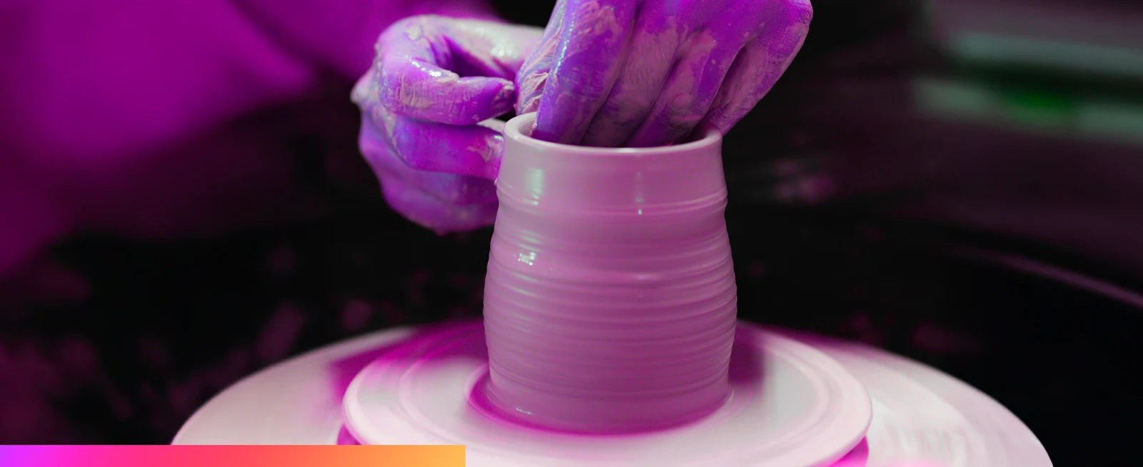 Hands shaping clay on a potter's wheel
